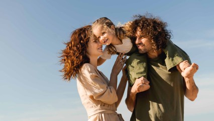 Un couple et leur enfant dehors, complices