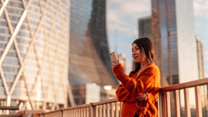 Femme sur un pont, son téléphone à la main