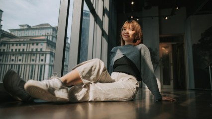 Femme assise face à une verrière donnant sur la ville
