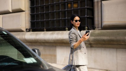 Femme d'affaire dans la rue, tenant son téléphone