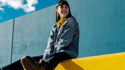 Femme assise sur un mur coloré