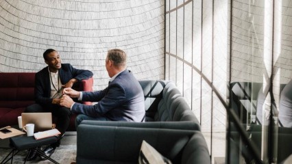 Deux hommes discutant dans un canapé