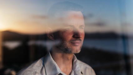 Homme regardant par la fenêtre