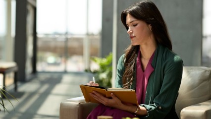 Femme assise, en train de prendre des notes