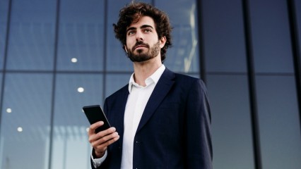 Homme d'affaire tenant son téléphone à la main