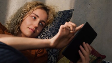 Femme allongée tenant son smartphone dans ses mains