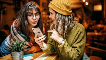 Deux femmes qui discutent devant un smartphone