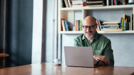 Homme assis à une table avec son pc