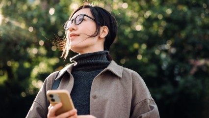 Femme à l'extérieur, un téléphone à la main