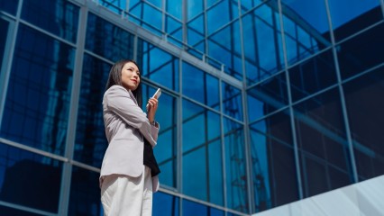 Femme d'affaires devant un immeuble moderne vitré