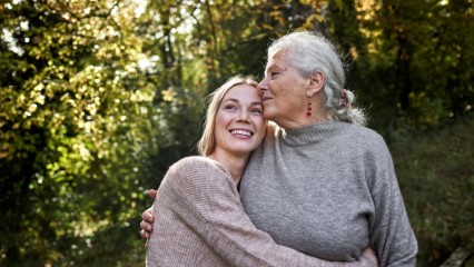 Une femme âgée et sa fille dans les bras, en balade dans la nature