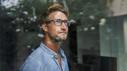 Homme pensif face à une vitre