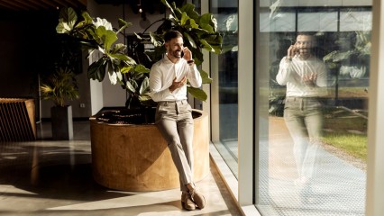 Homme au téléphone dans un espace professionnel clair et vitré