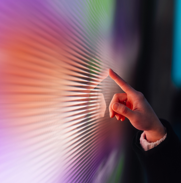 Doigt touchant un écran lumineux coloré