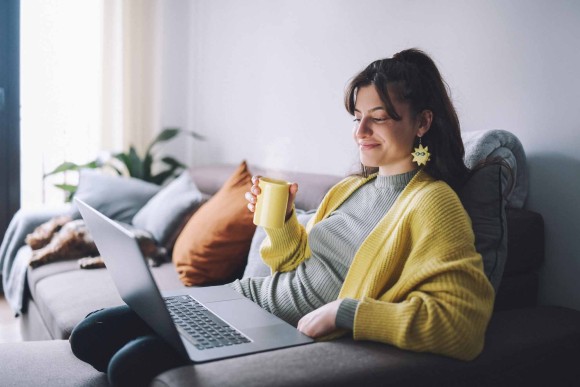 Femme qui regarde son PC en souriant