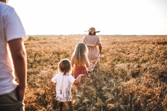 Famille avec enfants marchant dans un champ de blé